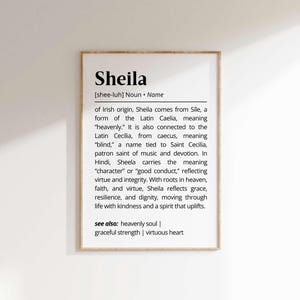 May include: A wooden-framed print featuring the name "Sheila" and its definition. The text explains the name's origins in Irish and Latin, its meanings, and its associations with virtues like grace and integrity.