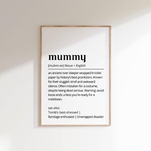 May include: A printable wall art design with a black and white definition of the word "mummy". The definition is a humorous description of a mother. The text includes the phonetic pronunciation of the word, "[muhm-ee]".