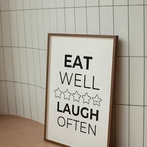 May include: A framed print with the text "EAT WELL LAUGH OFTEN" and five stars with a smiley face in the last star.