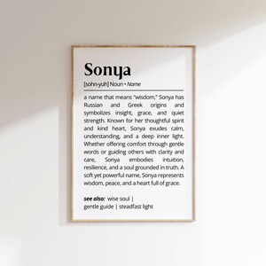 May include: A framed print featuring the name "Sonya" and its definition. The text describes the name's meaning, origins, and associated virtues. The frame is light brown, and the background is white. The print is suitable for home decor.