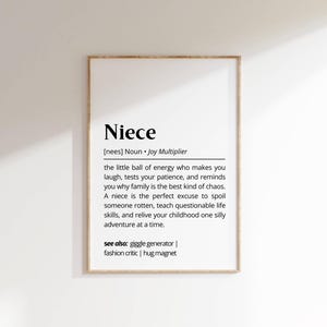 May include: A black and white printable wall art print with the word "Niece" defined as a "Joy Multiplier". The definition describes a niece as a "little ball of energy" who brings laughter, tests patience, and reminds you why family is the best kind of chaos. It also says a niece is the perfect excuse to spoil someone rotten, teach questionable life skills, and relive your childhood one silly adventure at a time. The print also includes the phrase "see also: giggle generator | fashion critic | hug magnet".