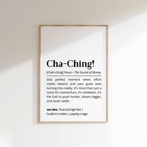 May include: A framed print featuring the word "Cha-Ching!" and its definition. The text describes the moment when effort meets reward. The print also includes related phrases such as "financial high-five" and "payday magic".