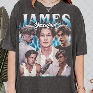 Puede incluir: Camiseta gris oscuro con un collage de imágenes de una persona, con el nombre "JAMES Beaufort" en una fuente estilizada. El diseño incluye gráficos de rayos azules y una estética vintage.