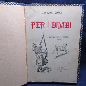 Può includere: Libro aperto con copertina vintage. Il titolo "PER I BIMBI" è in rosso. Un'illustrazione mostra un bambino con un fucile e un cane che corre. La copertina ha testo in alto e in basso, e le pagine sono ingiallite.