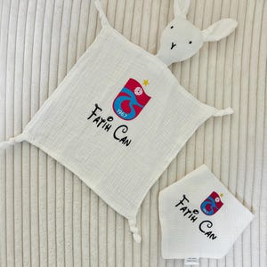 May include: White bunny-shaped baby security blanket with a red and blue logo and the text "Fatih Can 1967" embroidered on it.