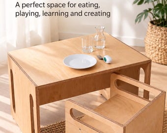 Pode incluir: Um conjunto de mesa e cadeira de madeira clara, composto por uma mesa retangular com painéis laterais recortados e uma cadeira baixa a condizer com pegas integradas. Sobre a mesa encontram-se um prato branco, um copo, uma jarra e um garfo.