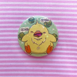 May include: A yellow chick with a wide open beak and the text "Kweh!" on a green and white button.