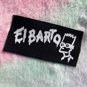 May include: Black rectangular patch with the text "El Barto" in dripping white letters and a white cartoon character outline. The patch is on a fluffy, multicolored background.