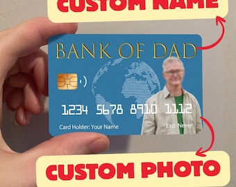 May include: A blue credit card with the text "BANK OF DAD" in gold lettering. The card features a photo and the text "CUSTOM PHOTO" and "CUSTOM NAME". The card number is 1234 5678 8910 1112. The expiration date reads "Exp: Never".