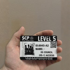 Op de afbeelding: Een zwart-witte Level 5 toegangskaart met de tekst "SCP Secure. Contain. Protect." De kaart heeft een QR-code en de tekst "ID:8945-A2 NAME: - 05 COUNCIL (05-1) ACCESS."
