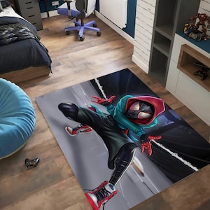 May include: A rug featuring a cartoon illustration of Spider-Man in a red and black suit with a blue and green hoodie. The character is posed in a dynamic action pose with one leg extended and the other bent at the knee. The background is a dark grey with white lines.