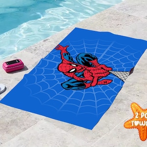 Pu&ograve; includere: Due asciugamani da spiaggia blu con un design Spiderman rosso e blu e un motivo a ragnatela bianca. Il testo "2 PCS TOWELS" &egrave; su una stella marina.