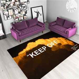 Può includere: Un tappeto nero e giallo con il testo "KEEP OFF" in bianco. Il tappeto presenta un design a forma di nuvola su uno sfondo scuro.