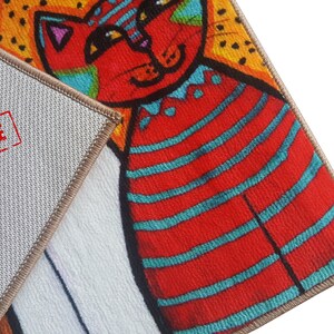Pu&ograve; includere: Primo piano di un tappeto colorato con un design di gatto a strisce rosse e blu. Il tappeto ha un retro beige con la parola "SAMPLE" stampata in rosso.