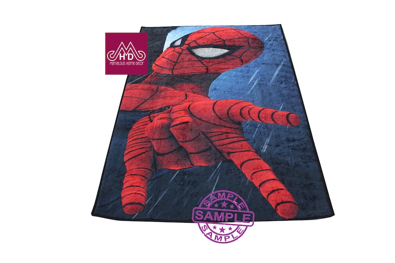 Puede incluir: Una alfombra roja y azul con una imagen de primer plano de la mano de Spider-Man extendi&eacute;ndose. La alfombra tiene un fondo azul oscuro con un patr&oacute;n de lluvia. El texto "SAMPLE" est&aacute; impreso en morado sobre un c&iacute;rculo blanco.