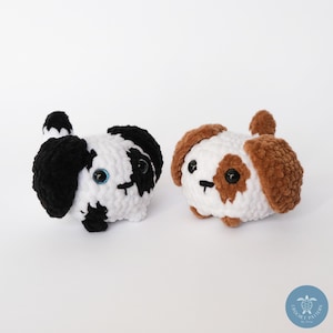 Pu&ograve; includere: Due giocattoli di peluche a forma di cane realizzati all'uncinetto. Uno &egrave; bianco e nero con occhi blu e l'altro &egrave; bianco e marrone con occhi neri.