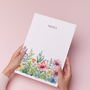 May include: A white notepad with the word "NOTES" printed at the top. The notepad has a watercolour border of colourful flowers and green leaves.