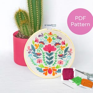Puede incluir: Un patrón de bordado floral colorido en un aro, con hilo y una aguja para coser. El patrón PDF está disponible para descargar.