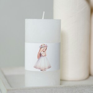 May include: White pillar candle with a floral wreath and a girl in a white dress on the label.