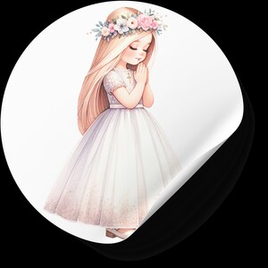 May include: A young girl in a white dress with a flower crown and a cross necklace, praying with her hands clasped together.