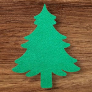 Puede incluir: Un recorte de árbol de Navidad de fieltro verde brillante sobre una superficie de madera marrón. El árbol tiene una forma clásica con múltiples ramas en capas y una parte superior puntiaguda. El fondo es una veta de madera cálida y natural.