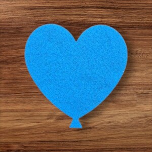 May include: A vibrant blue heart-shaped decoration, with a small triangular tail, like a balloon. The textured heart sits on a wooden surface. The image is a close-up shot, highlighting the heart's shape and texture.