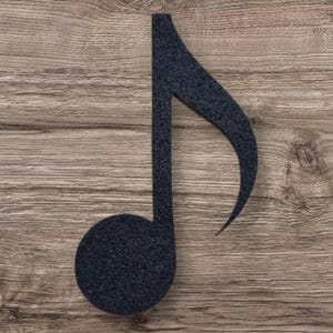May include: A dark charcoal gray musical note symbol crafted from a textured, felt-like material. The design features a solid circular base connected to a vertical stem that curves into a sharp, pointed tail at the top, creating a classic eighth note.
