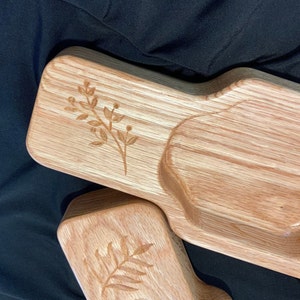 May include: A wooden serving tray with three compartments, each with a unique shape. The tray is made of light brown wood and has a natural finish. The tray is decorated with a simple floral design.
