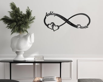May include: Black metal infinity symbol wall decor with the names Ashley and David and the date 11.12.1986. Two hearts are intertwined within the infinity symbol.