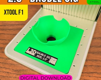 以下が含まれることがあります： 「2.5" BAUBLE JIG」と「XTOOL F1」の文字が入った緑色のオーナメントジグ。 ジグは緑色のベースと緑色の漏斗型のホルダーを備えています。 「L3D ACCESSORIES」と「DIGITAL DOWNLOAD」の文字も表示されています。 ジグのサイズは6.35cmです。