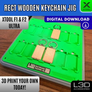May include: A green rectangular keychain jig with wooden keychains and silver key rings. The text "RECT WOODEN KEYCHAIN JIG" is at the top. The text "DIGITAL DOWNLOAD" is also visible. The text "3D PRINT YOUR OWN TODAY!" is at the bottom.
