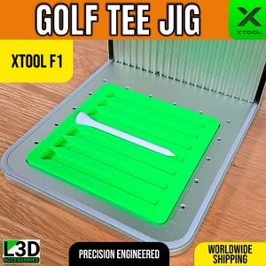以下が含まれることがあります： 「GOLF TEE JIG」と「XTOOL F1」の文字が入ったゴルフティー用ジグ。明るい緑色のインサートにはティー用のスロットがあり、白いゴルフティーがセットされています。ベースはシルバーカラーの金属製です。「PRECISION ENGINEERED」の文字も表示されています。