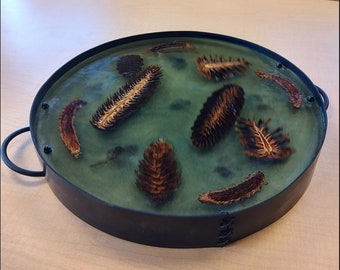 Hand made epoxy resin charcuterie tray with pinecones.  This is a hand made epoxy charcuterie board with handles.  It is food safe.