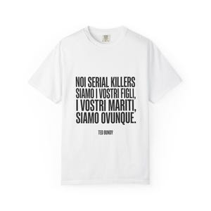 Può includere: Una t-shirt bianca a maniche corte con testo nero che recita: NOI SERIAL KILLERS SIAMO I VOSTRI FIGLI, I VOSTRI MARITI, SIAMO OVUNQUE. TED BUNDY. La maglia presenta un girocollo e una vestibilità standard, con il testo centrato.