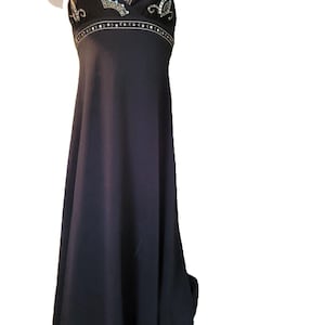 May include: A black evening gown with spaghetti straps. The bodice features ornate gold and silver embellishments. The dress has a flowing, floor-length skirt.