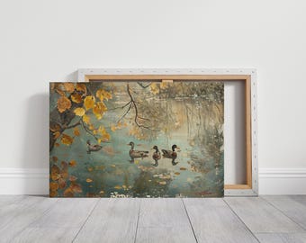 May include: A framed canvas print of an autumn scene with ducks on a pond. The artwork features a teal-colored pond with ducks, yellow leaves, and branches. The canvas is mounted on a wooden frame.