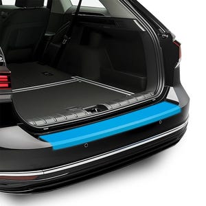 Può includere: Paraurti posteriore nero di un'auto con una striscia protettiva blu brillante. Il paraurti ha una finitura argentata e due piccoli sensori neri. Il bagagliaio dell'auto è aperto, rivelando un interno nero.