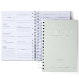 May include: A gray and white daily alignment journal with a spiral binding. The cover has the text "kosha fit" and "Daily Alignment Journal" in a silver embossed font. The bottom of the cover has the text "Body Energy Mind Wisdom Bliss" in a smaller font.