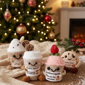 Könnte beinhalten: Vier gehäkelte Plüschtiere, bestehend aus einem Frappé mit dem Text A hug you can keep, einem Espresso mit Positive Espresso More Espresso Less Depresso, einem Cupcake mit Positive Cupcake You are the sweetest und einem Keks mit Happy Cookie.