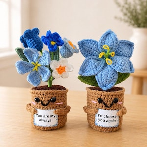 Peut inclure: Deux plantes en pot crochetées avec des pots marron arborant des visages souriants et de petits bras. Le pot de gauche contient un bouquet de fleurs bleues et blanches avec le texte "You are my always". Le pot de droite contient une grande fleur bleue avec le texte "I'd choose you again".