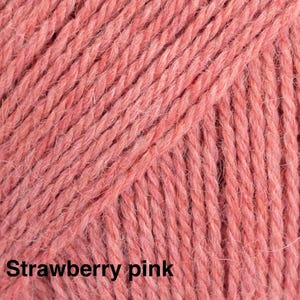 May include: A close-up view of a skein of yarn in a solid strawberry pink colour. The yarn features a multi-ply twisted texture with a soft, slightly fuzzy appearance. The text "Strawberry pink" is printed in black at the bottom left corner.