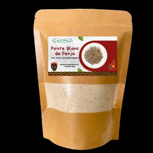 May include: A brown paper bag with a white label that reads "JELLS SPICES Poivre Blanc de Penja (Hot white grounded pepper)" and a picture of white peppercorns. The bag contains ground white pepper.