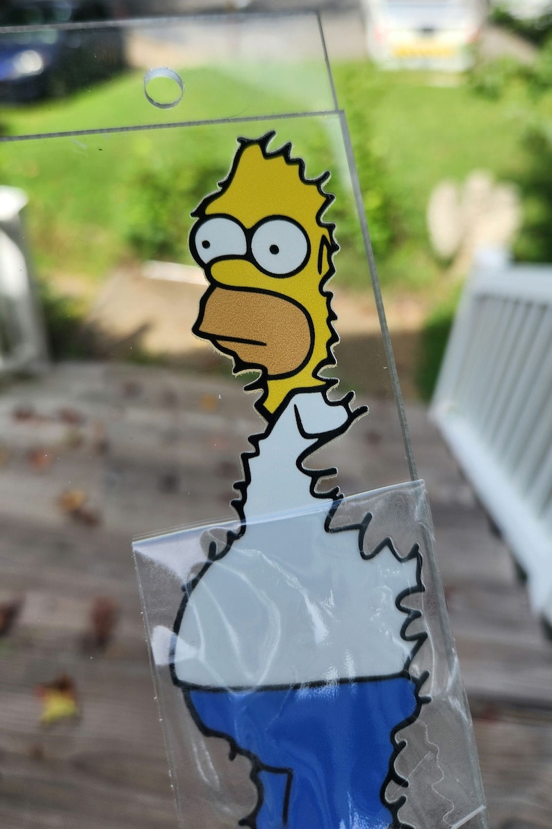 May include: A yellow cartoon character with blue pants and a white shirt. The character has a yellow head with two large eyes and a black outline. The character is looking to the left.