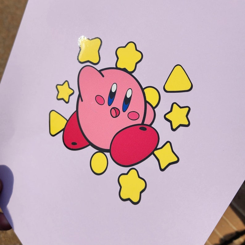 May include: A pink cartoon character with big eyes and a smile surrounded by yellow stars. The character is on a light purple background.