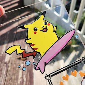 May include: A yellow cartoon Pikachu character riding a pink surfboard with a blue and white background.