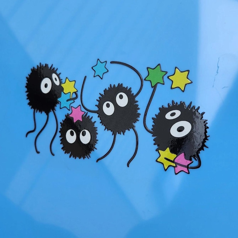 May include: Five black fuzzy creatures with large eyes and long legs are holding colorful stars on a light blue background.