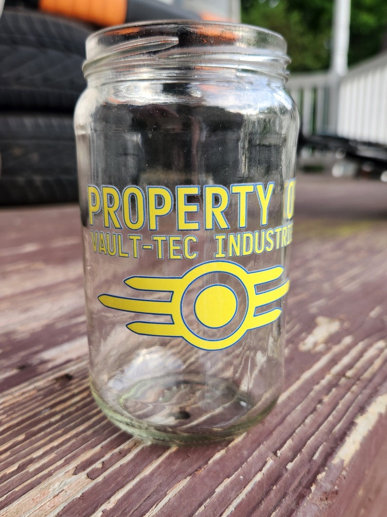May include: A clear glass jar with a yellow and blue Vault-Tec Industries logo that says "PROPERTY OF VAULT-TEC INDUSTRIES".