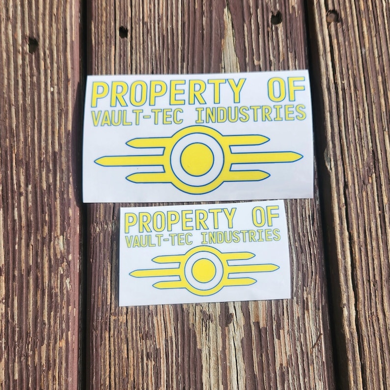 May include: Two white stickers with the text "PROPERTY OF VAULT-TEC INDUSTRIES" and a yellow and blue Vault-Tec logo.