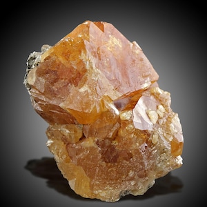 Scheelite avec moscovite de Xuebaoding, Chine. Scheelite avec une couleur particulièrement intense et des zones transparentes parfaites.
