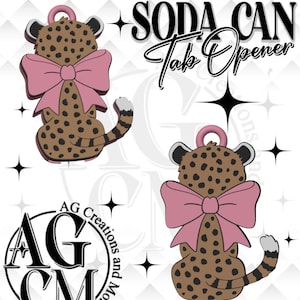 May include: A brown and black cheetah-shaped soda can tab opener with a pink bow. The opener has a ring for easy hanging. The text "SODA CAN Tab Opener" is displayed above the cheetah design.